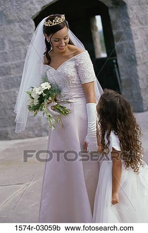 Bride holding a bouquet of flowers talking to a flower girl View Large Photo Image Stock Image - Bride holding a bouquet of flowers talking to a flower girl. Fotosearch