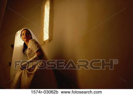 Stock Image - Bride walking up stairs. Fotosearch