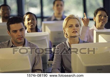 Business executives sitting in front of computer monitors in an office View Large Photo Image Stock Image - Business executives sitting in front of computer monitors in an office. Fotosearch