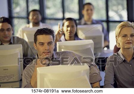 Business executives sitting in front of computer monitors in an office View Large Photo Image Stock Image - Business executives sitting in front of computer monitors in an office. Fotosearch