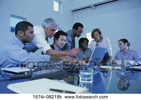 Stock Image - Business executives sitting together in a conference room. Fotosearch