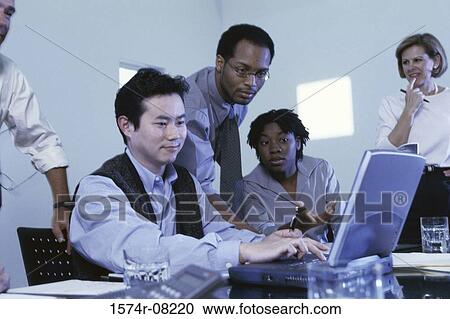 Stock Image - Business executives sitting together in a conference room. Fotosearch