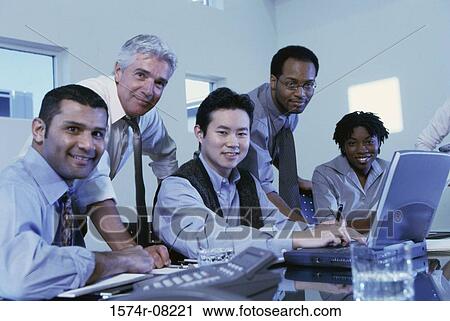 Stock Image - Business executives sitting together in a conference room. Fotosearch