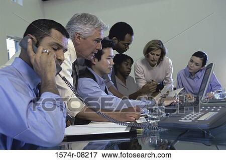 Stock Photo - Business executives sitting together in a conference room. Fotosearch