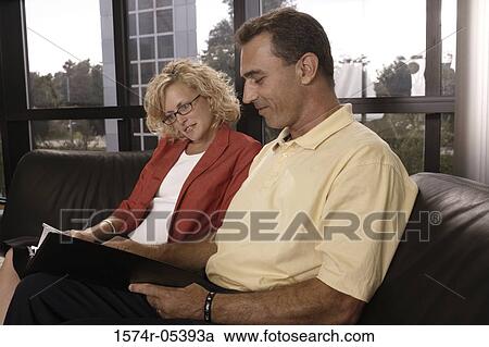 Stock Image - Businessman and a businesswoman looking at documents in an office. Fotosearch