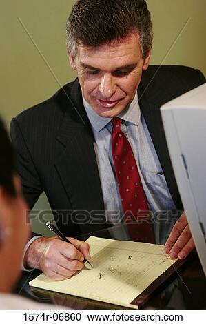 Businessman and a businesswoman sitting in an office View Large Photo Image Stock Image - Businessman and a businesswoman sitting in an office. Fotosearch