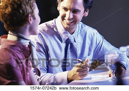 Businessman and a businesswoman sitting in a restaurant View Large Photo Image Stock Image - Businessman and a businesswoman sitting in a restaurant. Fotosearch