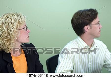 Stock Photo - Businessman and a businesswoman sitting in an office. Fotosearch
