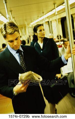Businessman and a businesswoman standing in a train View Large Photo Image Stock Image - Businessman and a businesswoman standing in a train. Fotosearch