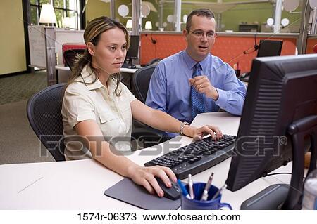 Businessman and a businesswoman working on a computer View Large Photo Image Stock Image - Businessman and a businesswoman working on a computer. Fotosearch