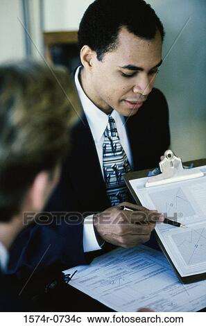 Stock Image - Businessman explaining a document. Fotosearch