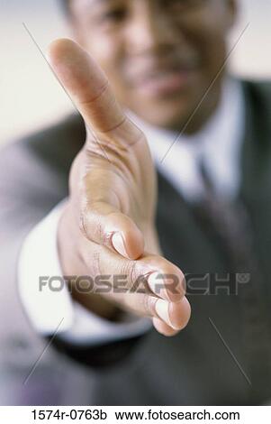 Stock Image - Businessman extending his hand for a handshake. Fotosearch