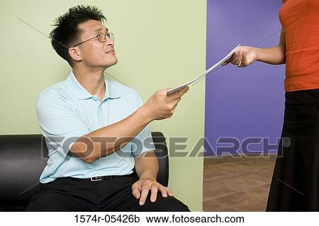Businessman giving a document to a businesswoman View Large Photo Image Stock Image - Businessman giving a document to a businesswoman. Fotosearch