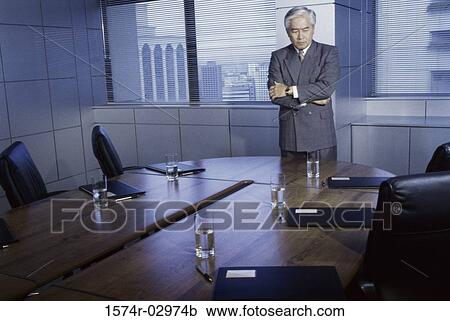 Businessman leaning on a conference table View Large Photo Image Stock Image - Businessman leaning on a conference table. Fotosearch