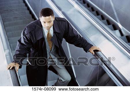 Businessman on an escalator View Large Photo Image Stock Photo - Businessman on an escalator. Fotosearch