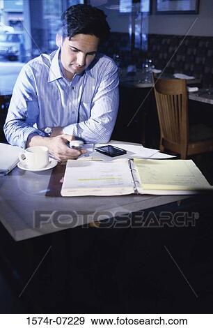 Businessman operating a mobile phone View Large Photo Image Stock Photo - Businessman operating a mobile phone. Fotosearch