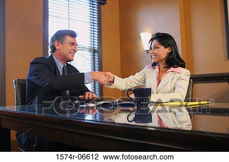 Businessman shaking hands with a businesswoman View Large Photo Image Stock Image - Businessman shaking hands with a businesswoman. Fotosearch