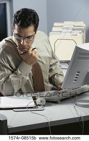 Businessman sitting at a desk View Large Photo Image Stock Image - Businessman sitting at a desk. Fotosearch