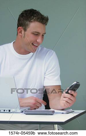 Businessman sitting holding a mobile phone View Large Photo Image Stock Image - Businessman sitting holding a mobile phone. Fotosearch
