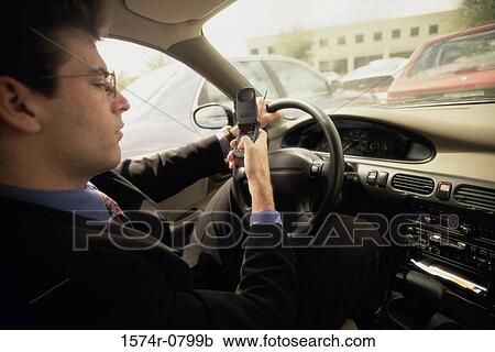 Businessman sitting in a car using a mobile phone View Large Photo Image Stock Image - Businessman sitting in a car using a mobile phone. Fotosearch