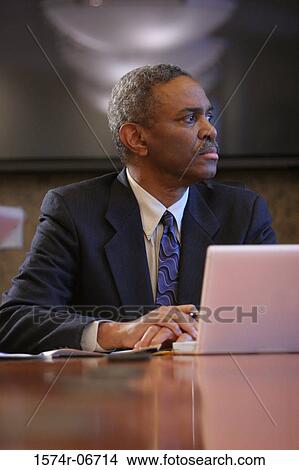 Businessman sitting in a conference room View Large Photo Image Picture - Businessman sitting in a conference room. Fotosearch