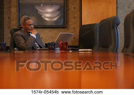 Businessman sitting in a conference room View Large Photo Image Stock Image - Businessman sitting in a conference room. Fotosearch