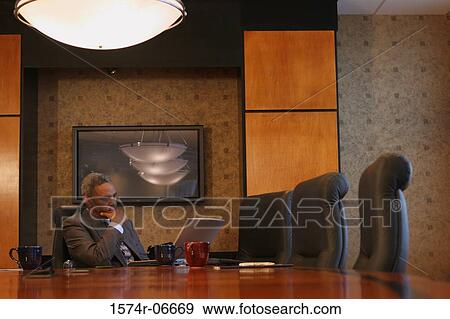 Stock Photo - Businessman sitting in a conference room. Fotosearch