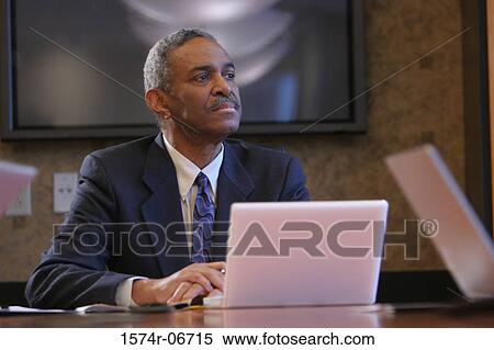 Businessman sitting in a conference room View Large Photo Image Stock Photography - Businessman sitting in a conference room. Fotosearch