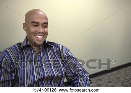 Stock Photograph - Businessman smiling in an office. Fotosearch
