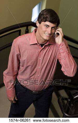 Businessman standing on a staircase talking on a mobile phone View Large Photo Image Stock Image - Businessman standing on a staircase talking on a mobile phone. Fotosearch