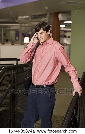 Businessman talking on a mobile phone in an office View Large Photo Image Stock Image - Businessman talking on a mobile phone in an office. Fotosearch