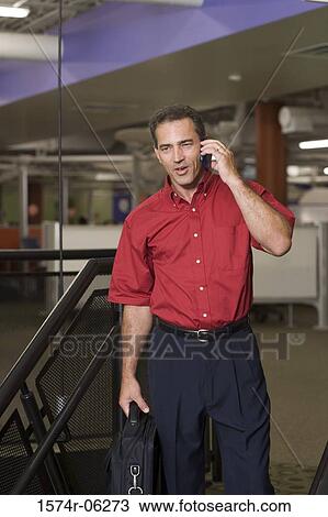 Businessman talking on a mobile phone in an office View Large Photo Image Stock Image - Businessman talking on a mobile phone in an office. Fotosearch