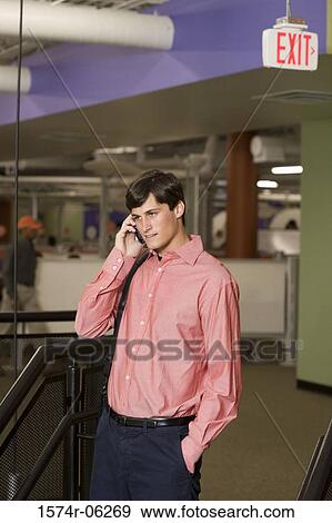 Businessman talking on a mobile phone in an office View Large Photo Image Stock Photo - Businessman talking on a mobile phone in an office. Fotosearch