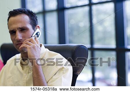 Businessman using a mobile phone in an office View Large Photo Image Stock Image - Businessman using a mobile phone in an office. Fotosearch
