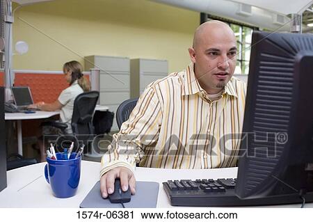 Stock Image - Businessman working on a computer in an office. Fotosearch