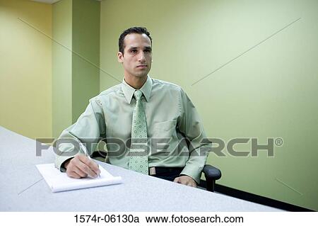 Businessman writing on a notepad in an office View Large Photo Image Stock Image - Businessman writing on a notepad in an office. Fotosearch