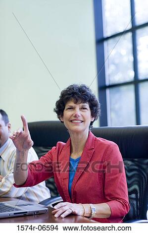 Businesswoman and a businessman sitting in an office View Large Photo Image Picture - Businesswoman and a businessman sitting in an office. Fotosearch