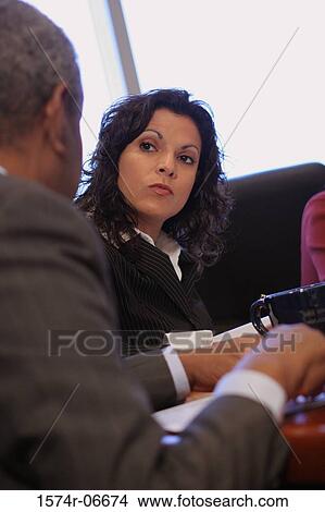 Businesswoman and a businessman sitting in an office View Large Photo Image Picture - Businesswoman and a businessman sitting in an office. Fotosearch