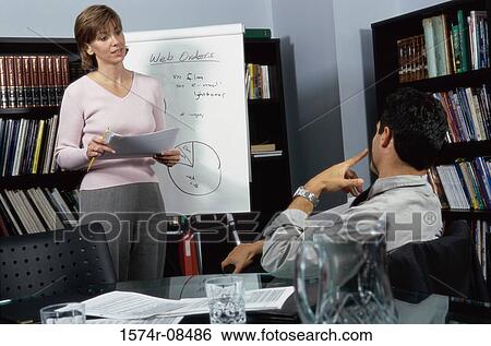 Businesswoman and a businessman discussing in an office View Large Photo Image Stock Photograph - Businesswoman and a businessman discussing in an office. Fotosearch