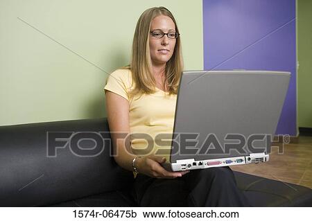 Businesswoman holding a laptop in an office View Large Photo Image Stock Image - Businesswoman holding a laptop in an office. Fotosearch