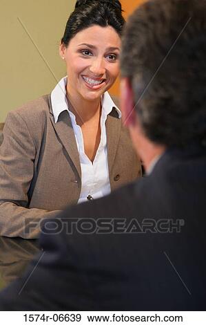Businesswoman looking at a businessman in an office View Large Photo Image Stock Photo - Businesswoman looking at a businessman in an office. Fotosearch