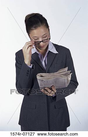 Businesswoman reading a newspaper View Large Photo Image Stock Photo - Businesswoman reading a newspaper. Fotosearch