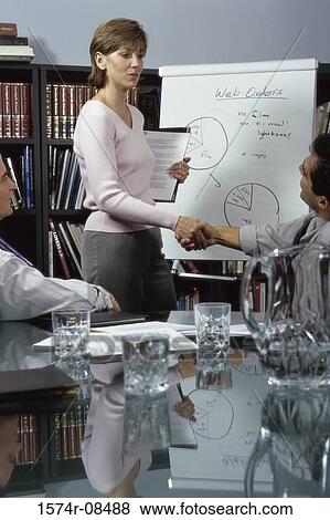 Businesswoman shaking hands with a businessman in an office View Large Photo Image Stock Photo - Businesswoman shaking hands with a businessman in an office. Fotosearch