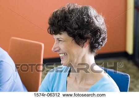 Stock Image - Businesswoman sitting in a conference room. Fotosearch