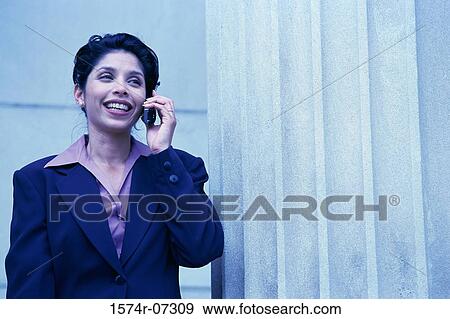 Stock Photo - Businesswoman talking on a mobile phone smiling. Fotosearch