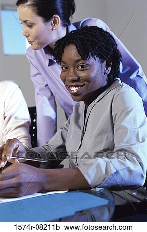 Businesswomen discussing in an office View Large Photo Image Stock Image - Businesswomen discussing in an office. Fotosearch