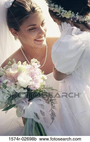 Stock Image - Close-up of a bride smiling at a flower girl. Fotosearch