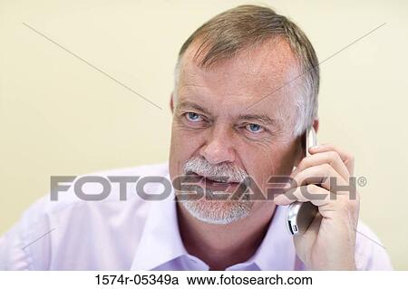 Close-up of a businessman talking on a mobile phone in an office View Large Photo Image Stock Image - Close-up of a businessman talking on a mobile phone in an office. Fotosearch