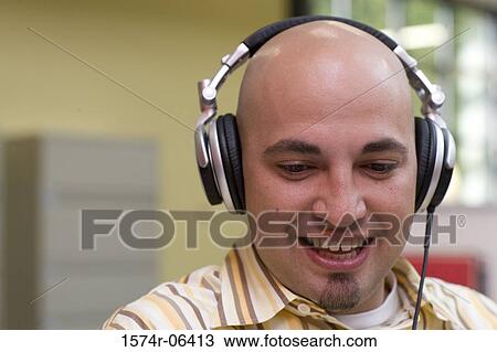 Close-up of a businessman wearing headphones in an office View Large Photo Image Stock Image - Close-up of a businessman wearing headphones in an office. Fotosearch