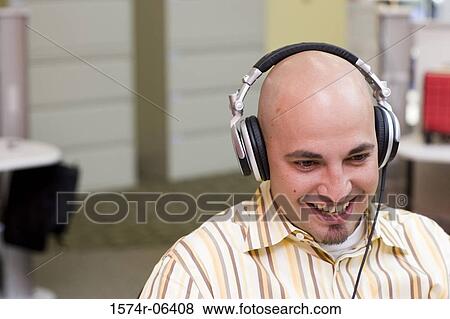 Close-up of a businessman wearing headphones in an office View Large Photo Image Stock Photo - Close-up of a businessman wearing headphones in an office. Fotosearch